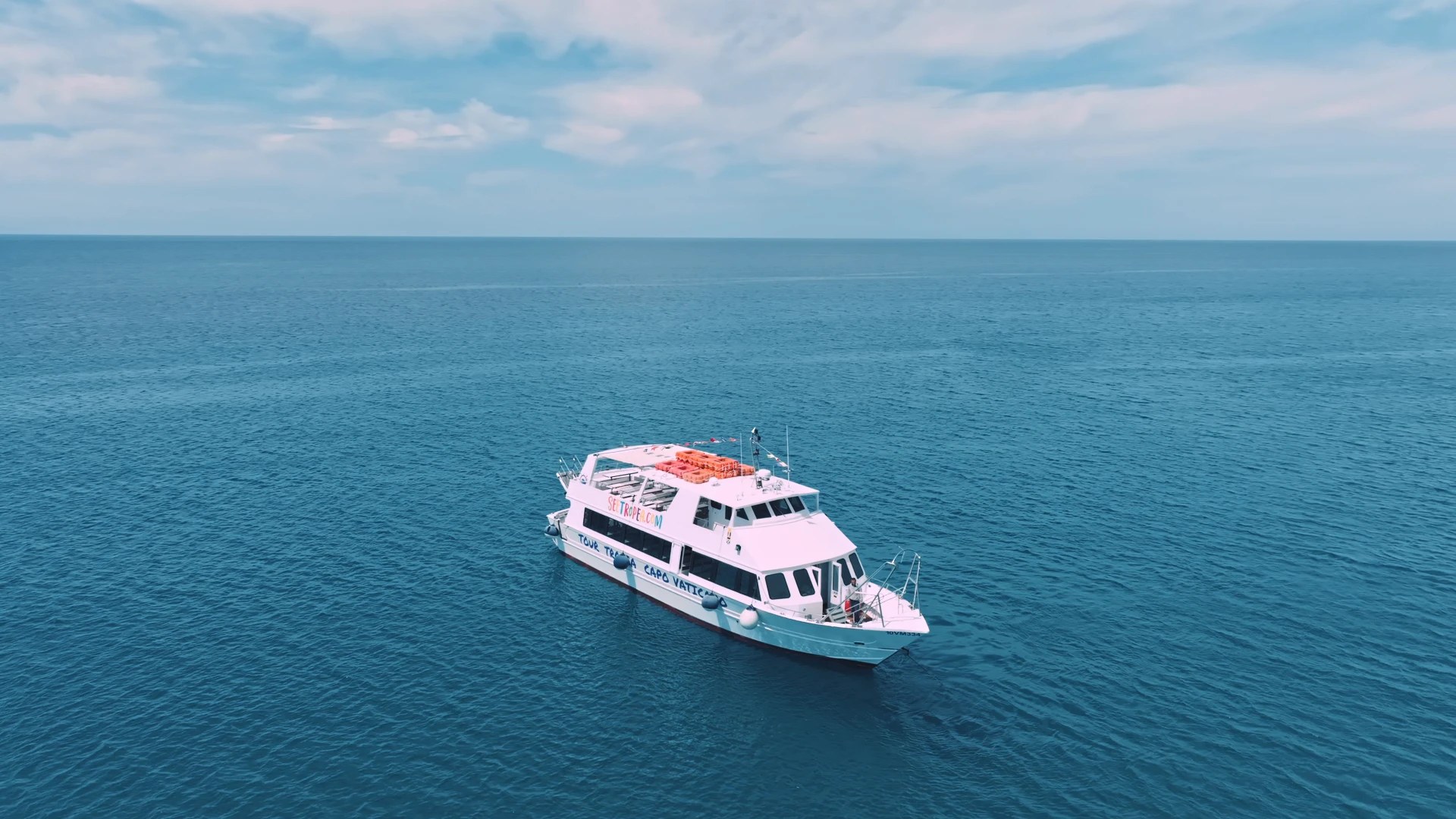 Motonave bianca SeeTropea con scritta «Tour Tropea Capo Vaticano» sulla fiancata, ferma in mare aperto sotto cielo velato